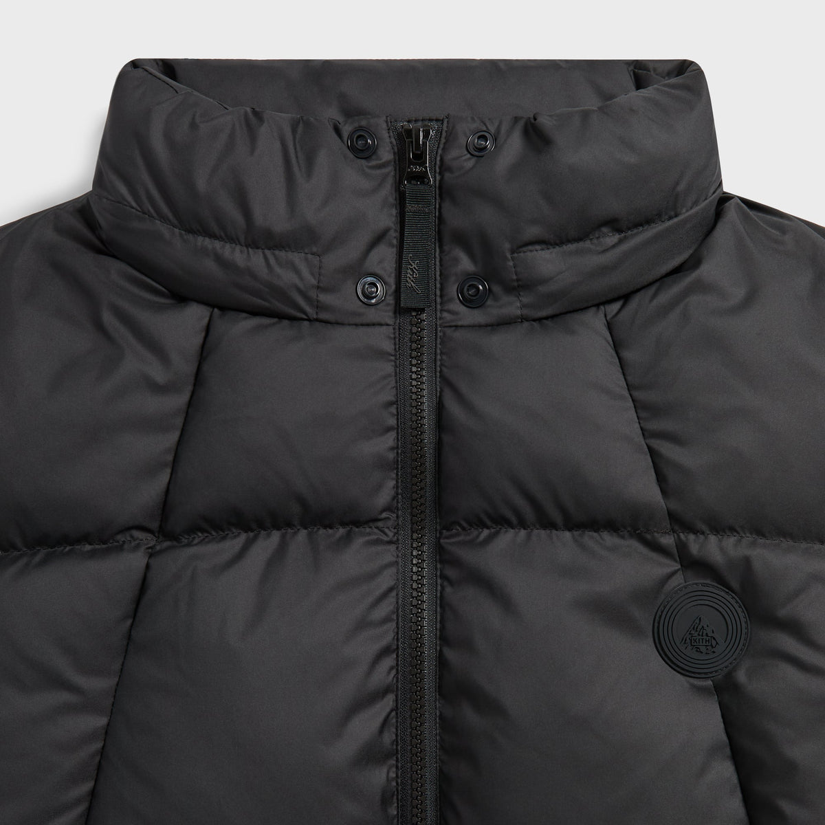Close-up of the hood, collar zip and tonal logo on the black Matte Taffeta puffer