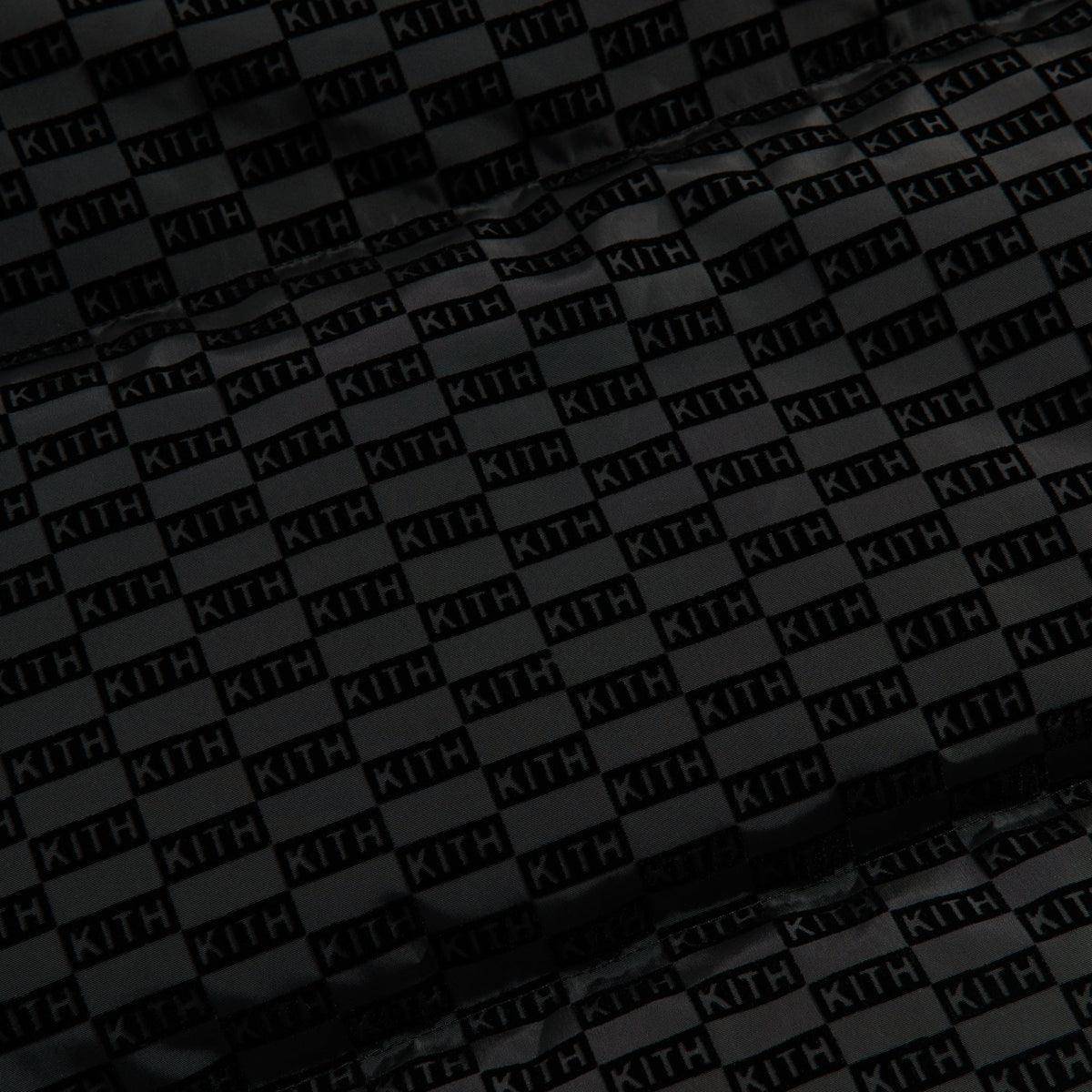 Close-up of the tonal KITH monogram flocked nylon fabric of the Kith Westley puffer