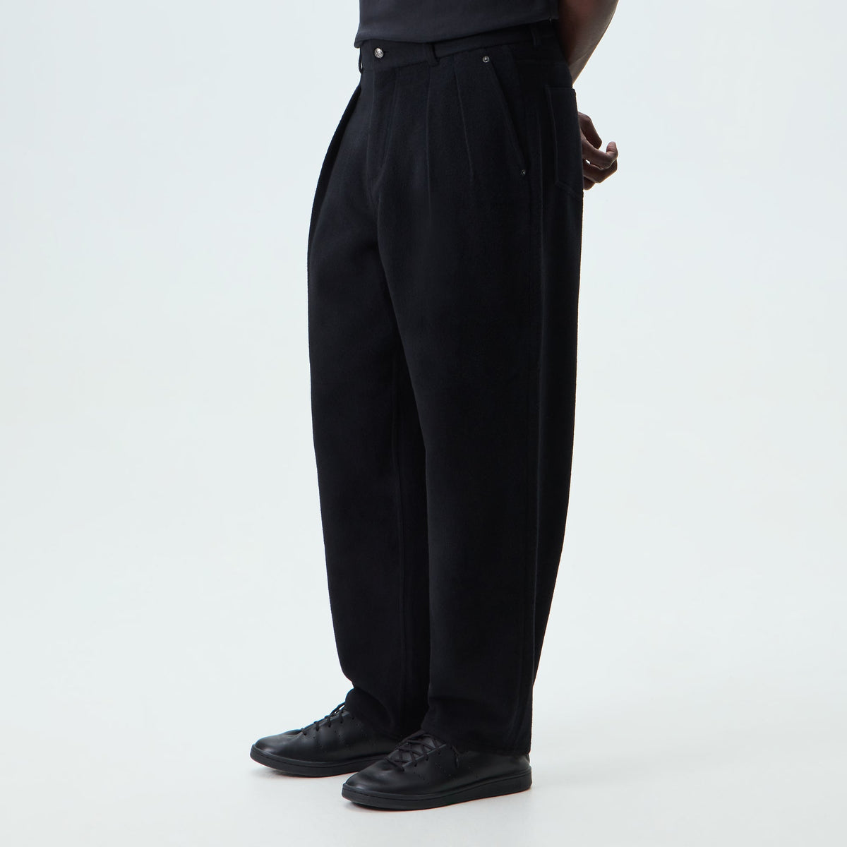Man wearing black &Kin Wool Cashmere Brett pleated trousers, side view